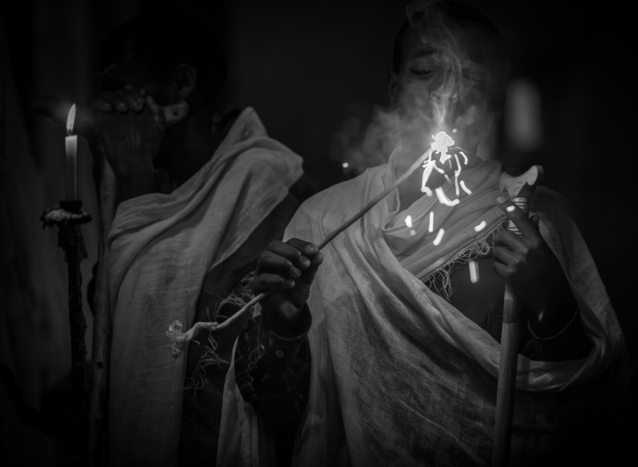 Ruce kněze s kadidlem a plamenem svíčky během bohoslužby, Lalibela, Etiopie