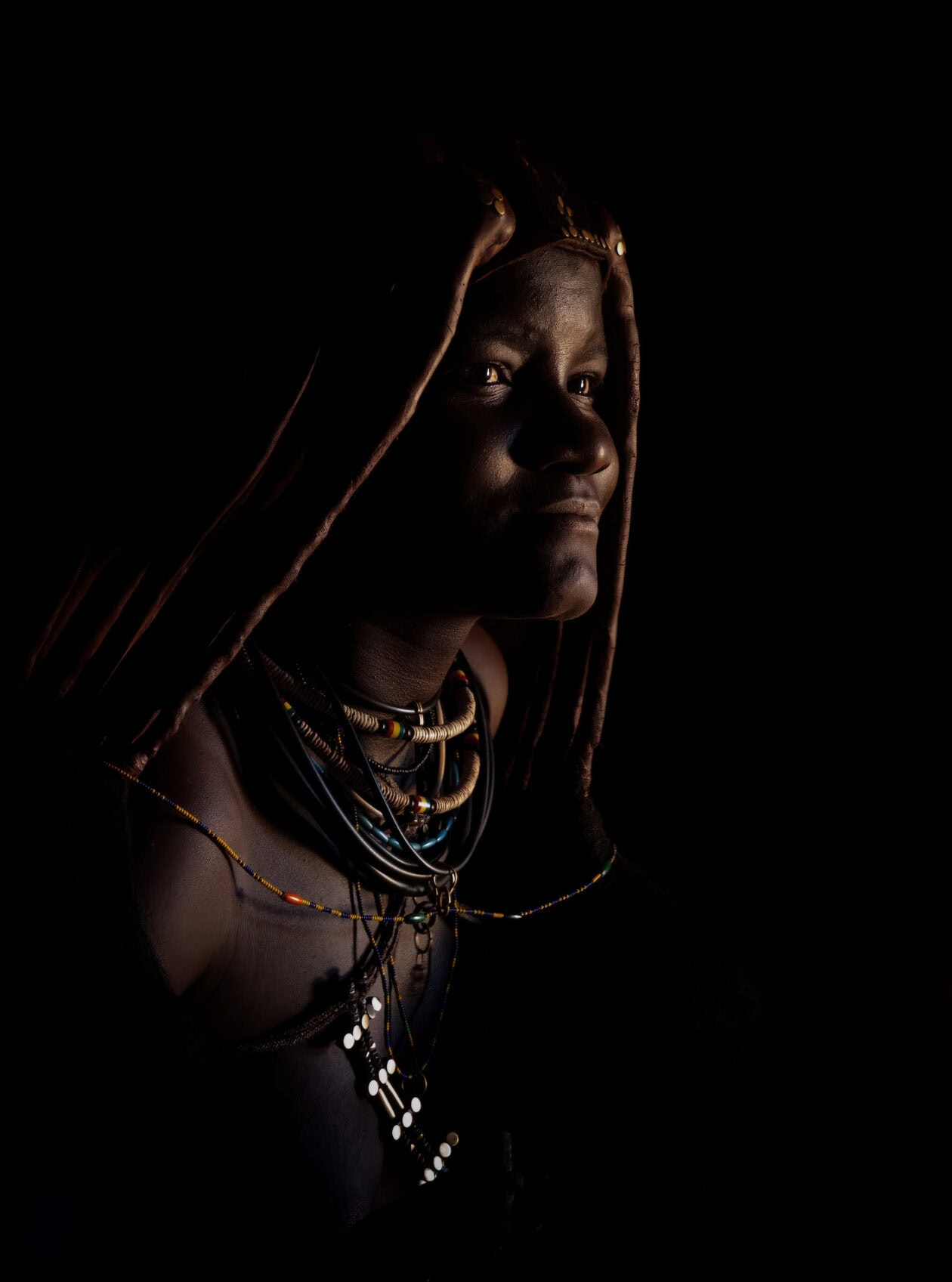 Žena kmene Himba s tradičními šperky a ozdobami otjize, portrét, Namibie