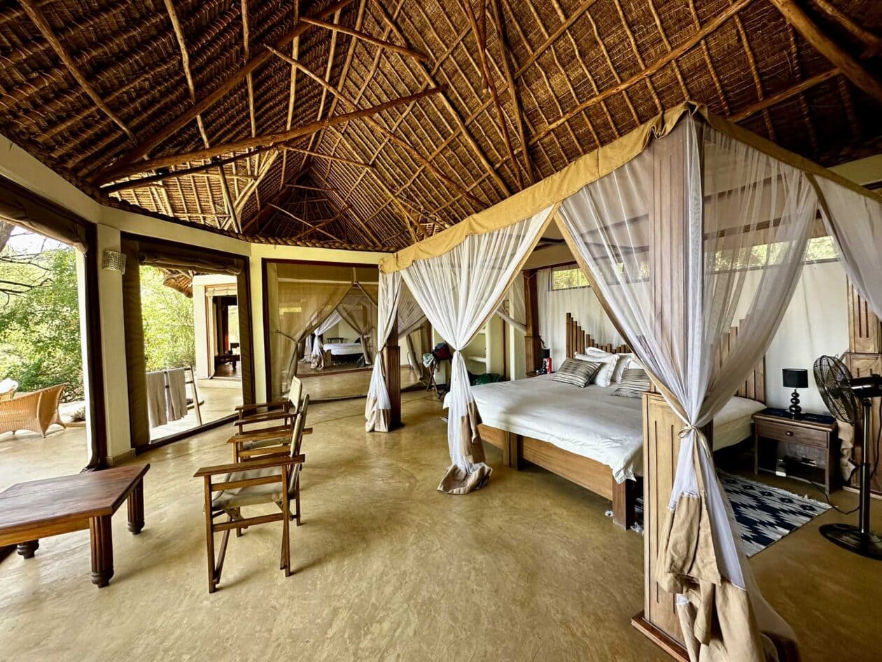 Interiér stanu Lentorre Lodge s moskytiérou a výhledem do přírody, Keňa