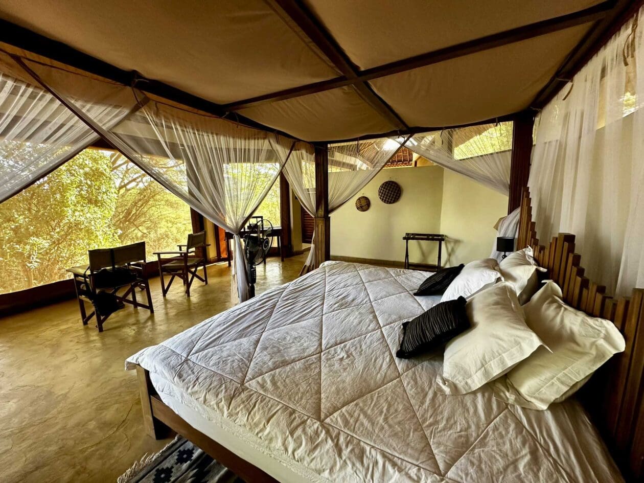Interiér stanu Lentorre Lodge s postelí pod moskytiérou, Keňa